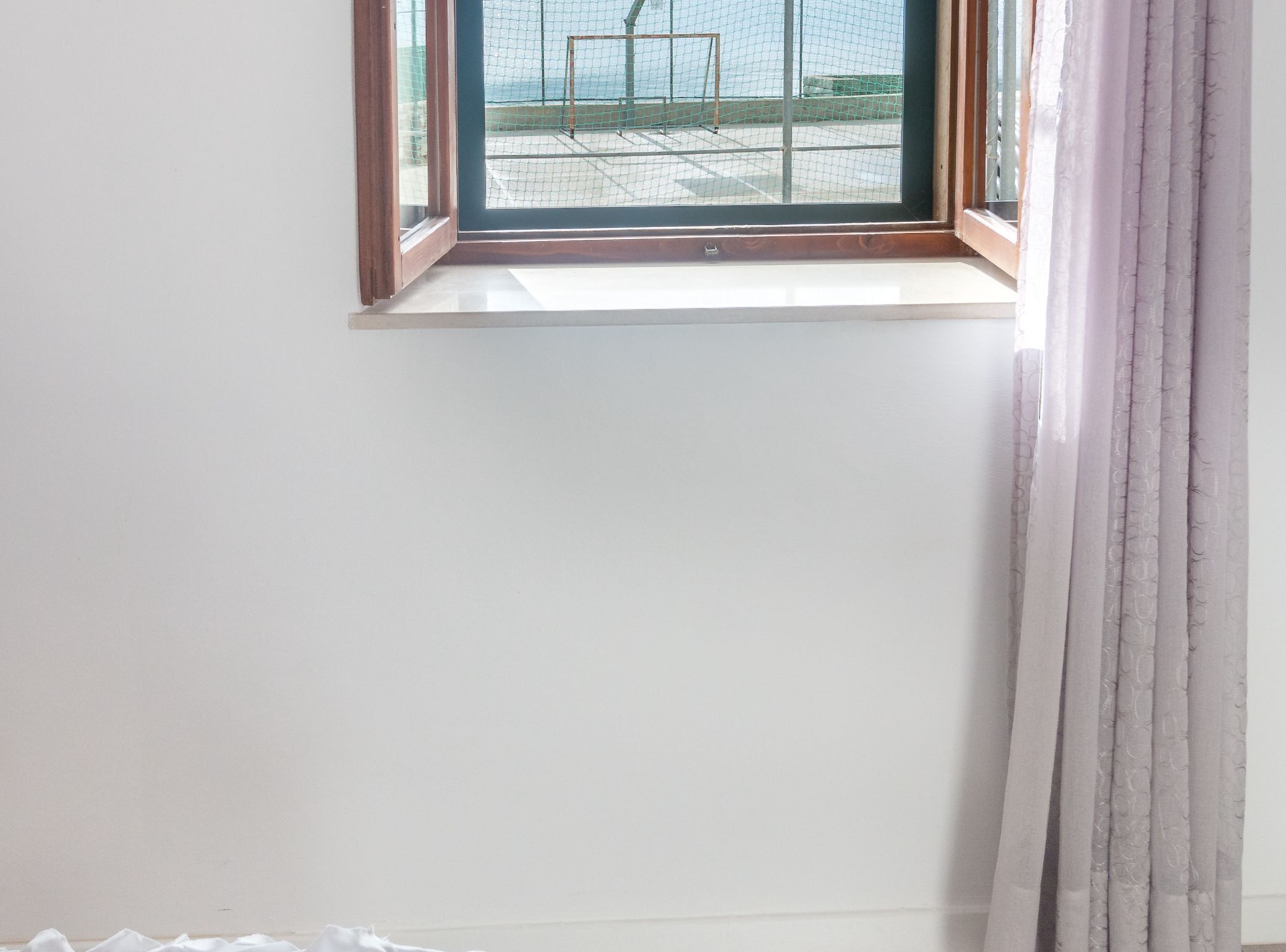 Una habitación con ventana y vistas a un balcón.