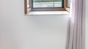 Una habitación con ventana y vistas a un balcón.