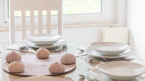 A dining table set with plates, cutlery, and decorative items. - Holiday Home Riva (Ston)