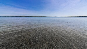 Una vista despejada de un lago con dos patos a lo lejos.