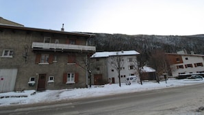 A two-story building with a balcony, a garage, and a snow-covered landscape in the background. - Ground floor, tv, ski locker, 55m², Val Cenis (Lanslebourg-Mont-Cenis)