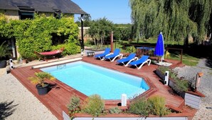 A swimming pool with blue lounge chairs and a hammock. - La Cour Saint Richer (Basseneville)