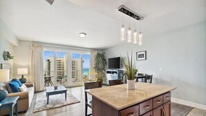 Eine moderne Wohnung mit Kücheninsel, Essbereich und Wohnzimmer mit Meerblick.