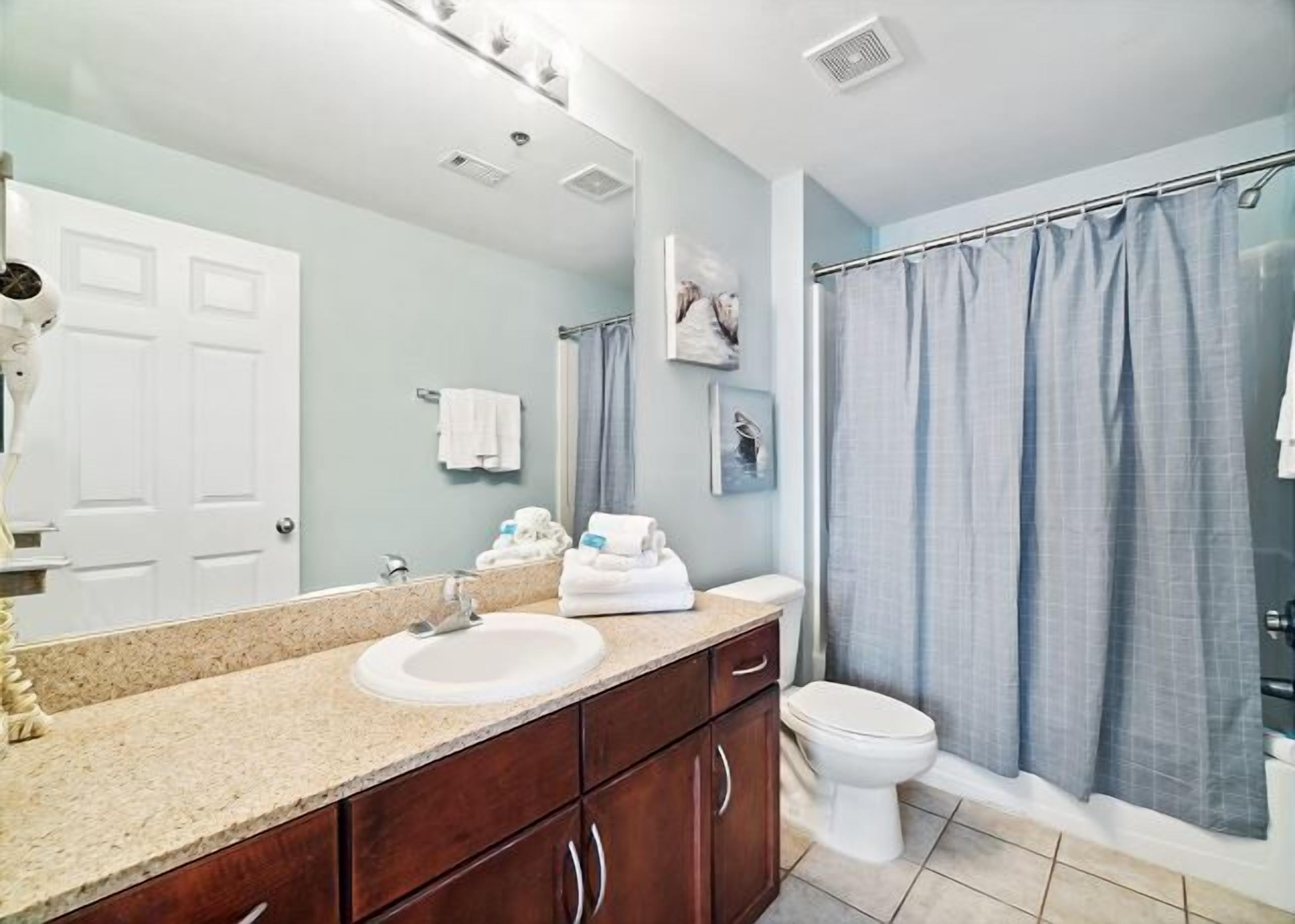 A bathroom with a sink, mirror, and toilet.