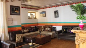 Una sala de estar con un sofá modular, una mesa de centro y un jarrón decorativo.