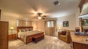 A bedroom with a bed, bedside tables, a ceiling fan, a dresser, a couch, and a window with curtains. - WW H202 Mather Street Retreat (NEW BRAUNFELS)