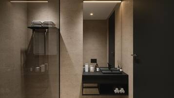 Une salle de bain moderne avec une douche à parois de verre, un meuble-lavabo noir avec un miroir et un éclairage encastré au plafond.