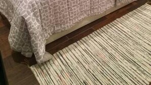 A bedroom with a bed, a patterned bedspread, and a striped rug. - Pet-Friendly House Steps from Midtown Excitement (Omaha)