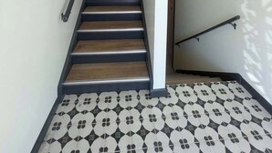 A staircase with wooden steps and metal handrails, leading to an upper floor. - Steps From UNMC, Dining, Explore Midtown (Omaha)