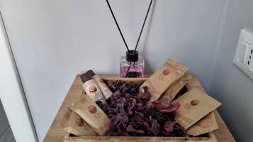 A wooden box containing dried flowers, a diffuser, and two bottles of Dune Italy shampoo.