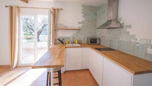 A kitchen with a wooden countertop, white cabinets, a microwave, and a stainless steel range hood. - Authentic Provencal Villa with Pool For a Perfect Family Retreat (La Ciotat)