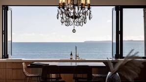 Una cocina con vista al mar, un candelabro y un florero con plumas.