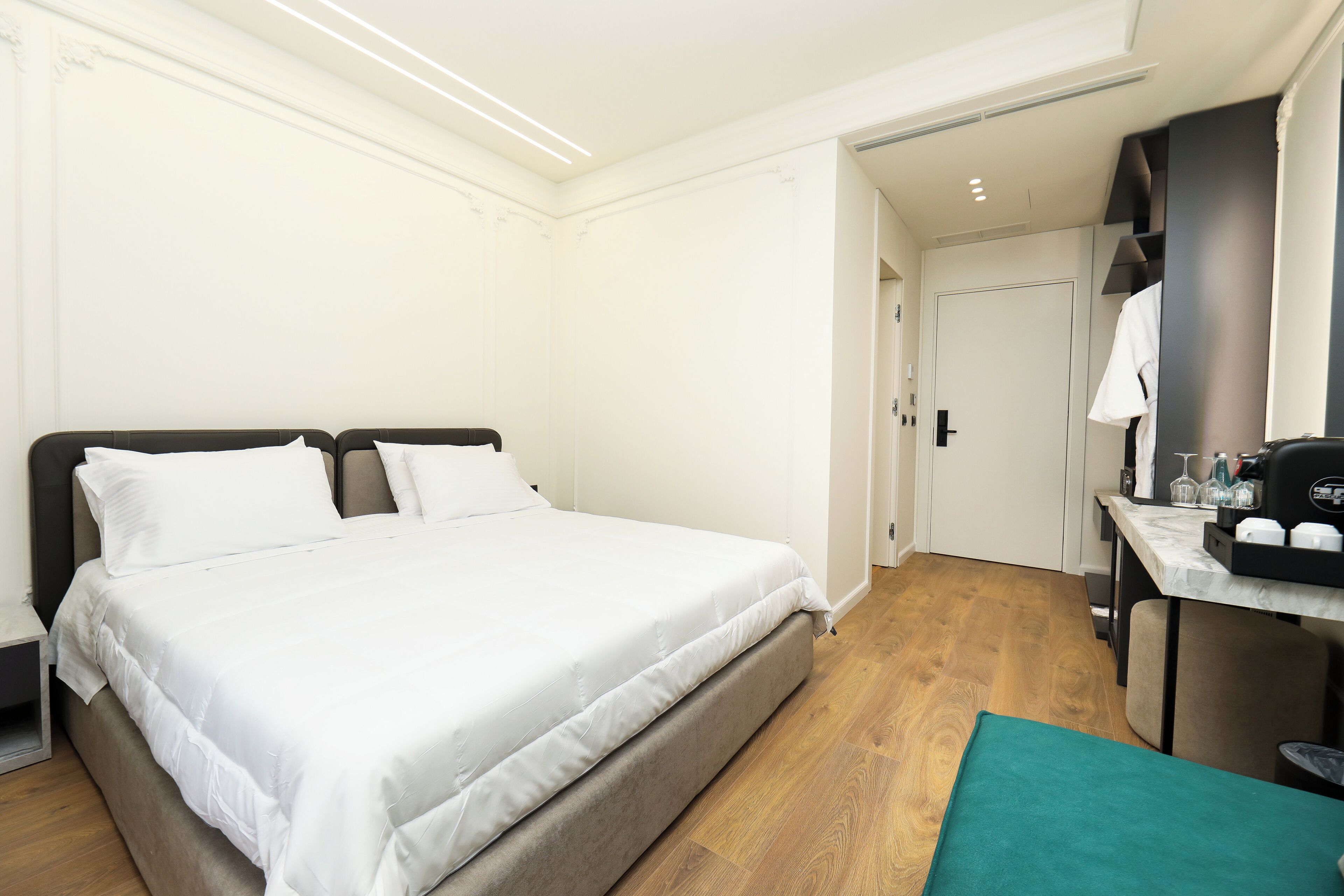A hotel room with a bed, a desk, and a bathroom visible through an open door.