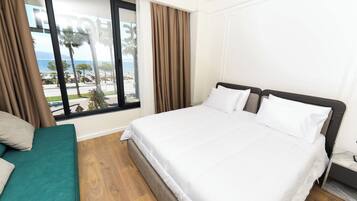 Deluxe driepersoonskamer, uitzicht op zee | Een minibar, geluiddichte muren, beddengoed