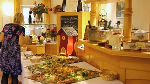 A buffet setup with various food items and a sign in German. - Weinhotel Kienle (Burrweiler)