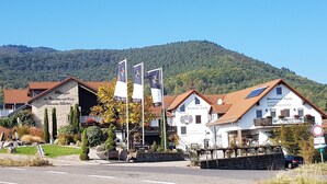 A traditional European building with a stone facade, a red-tiled roof, and a sign indicating it is a Weinhaus. - Weinhotel Kienle (Burrweiler)