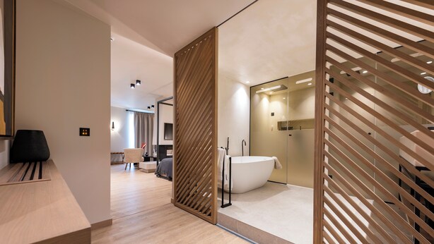 Een moderne badkamer met een vrijstaand bad, houten lattenwanden en een minimalistisch design.