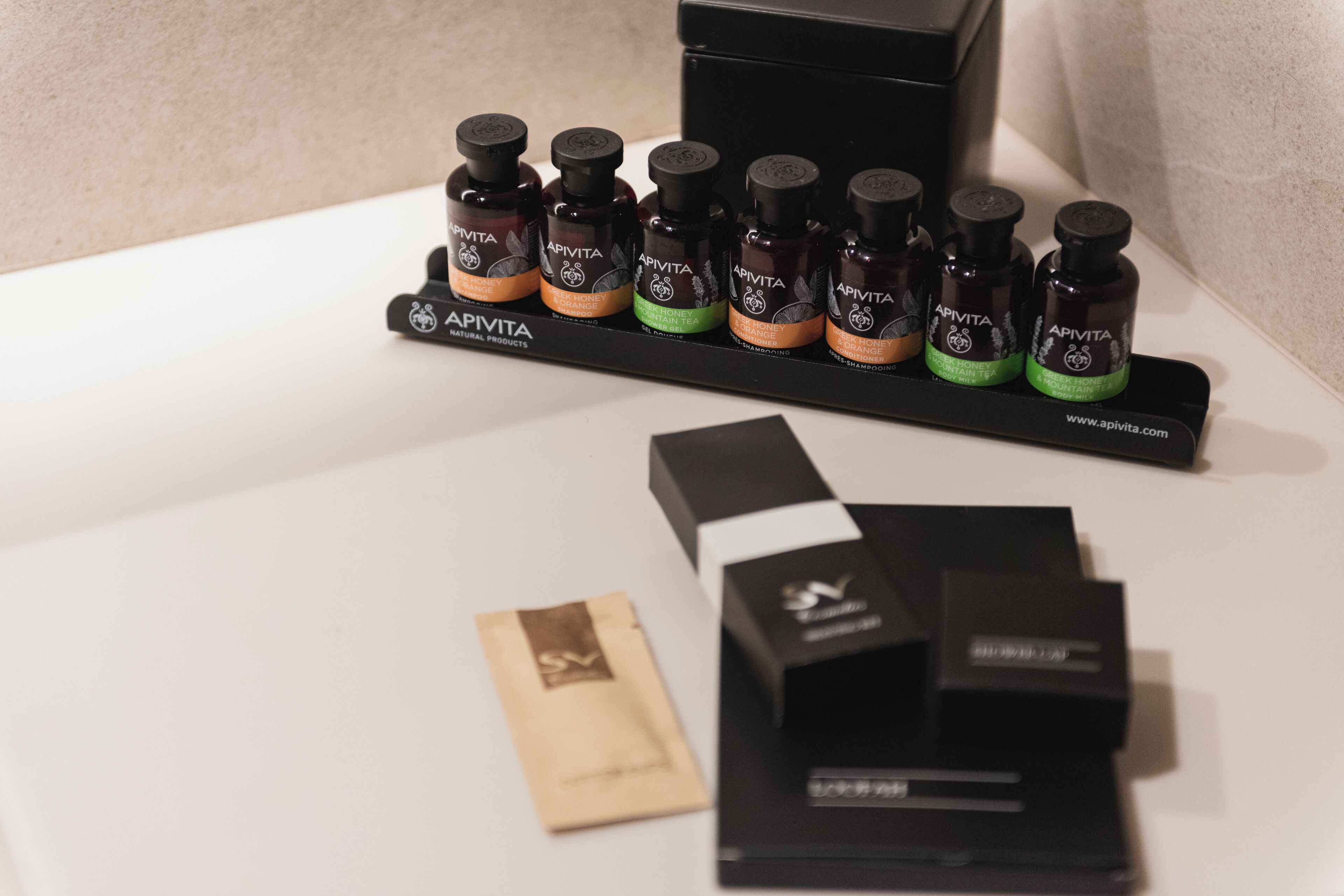 A display of Apivita natural products, including various bottles and boxes on a table.