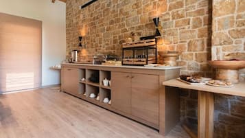 Una cocina con pared de piedra, armarios de madera y encimera con alimentos.