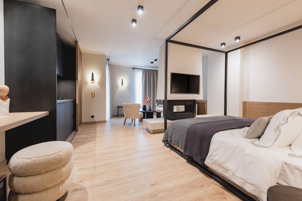 A modern hotel room with a bed, bedside table, and a TV mounted on the wall.