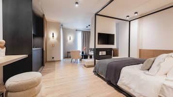 Une chambre d’hôtel moderne équipée d’un lit, d’une table de chevet et d’un téléviseur fixé au mur.