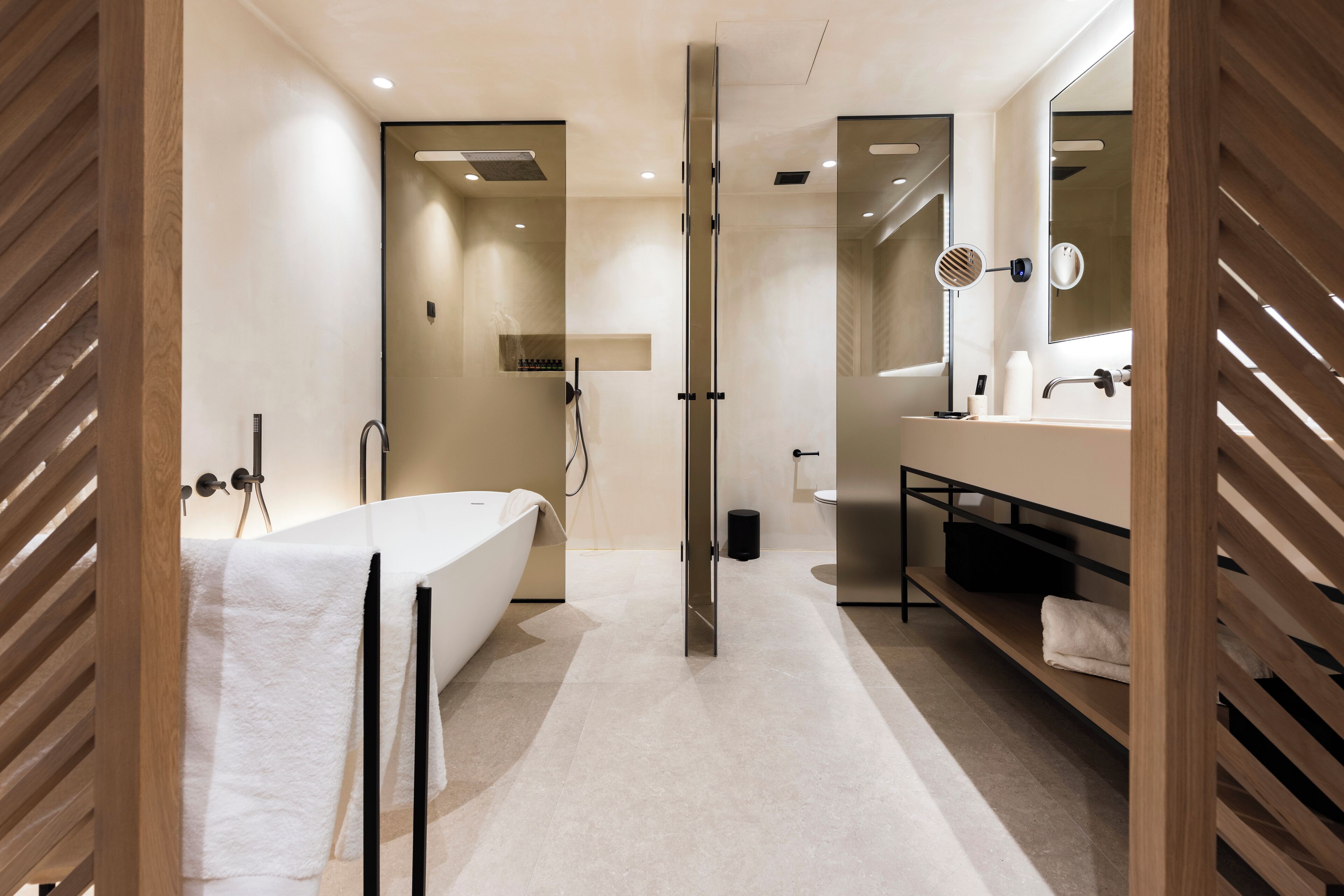 A modern bathroom with a bathtub, shower, and vanity.
