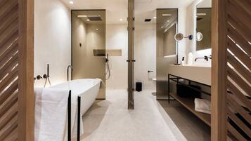 A modern bathroom with a bathtub, shower, and vanity.
