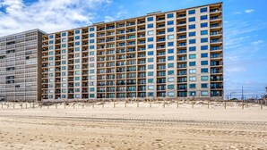 Ein mehrstöckiges Hotel mit modernem Design, das eine Reihe von Balkonen und große Fenster aufweist.