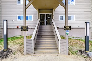 Staircase leads to the main entrance, flanked by signs for storage and main entry.