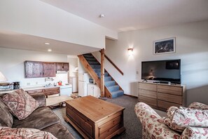 Relax in this open-plan living space with a kitchen, dining area, and comfortable sofa.
