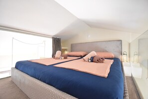 A hotel room with a large bed, two bedside tables, a headboard, and a large window with curtains. - Luxury Apartment Premantura 600 from the beach (Premantura)