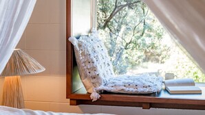 Ein gemütliches Zimmer mit Fensterbank, einer Lampe und einem Buch.