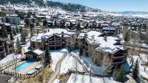 A resort with multiple buildings, a swimming pool, and a snow-covered landscape. - Mountain Retreat with A+ Location and Resort Amenities – Timberline Lodge 2309! (Steamboat Springs)