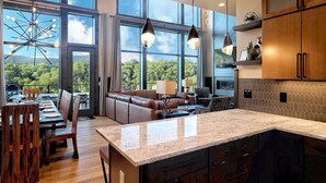 Una cocina moderna con ventanas amplias, un comedor con muebles de madera y vistas al exterior.