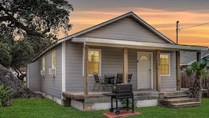 A single-story house with a porch, a grill, and a well-maintained lawn. - Flirtly Flamingo Rp203a 2 Bedroom Duplex by RedAwning (Rockport)