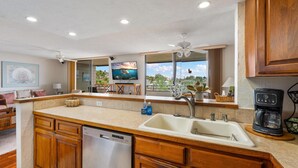 A modern kitchen with wooden cabinets, a dishwasher, a sink, and a coffee maker.