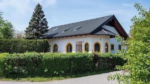 A white building with a sloped roof and arched windows. - Ganzes Haus für den Gruppen- und Familienurlaub (Klagenfurt am Wörthersee)