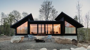 A modern cabin with large glass windows, a stone exterior, and a gravel driveway. - 58mf - Wi-fi - Pets Ok - Evc - Amazing Views 2 Bedroom Cabin by RedAwning (Maple Falls)