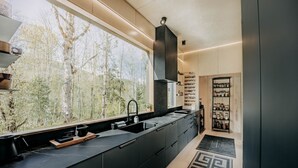 A modern kitchen with a large window, black cabinets, and a black countertop. - 58mf - Wi-fi - Pets Ok - Evc - Amazing Views 2 Bedroom Cabin by RedAwning (Maple Falls)