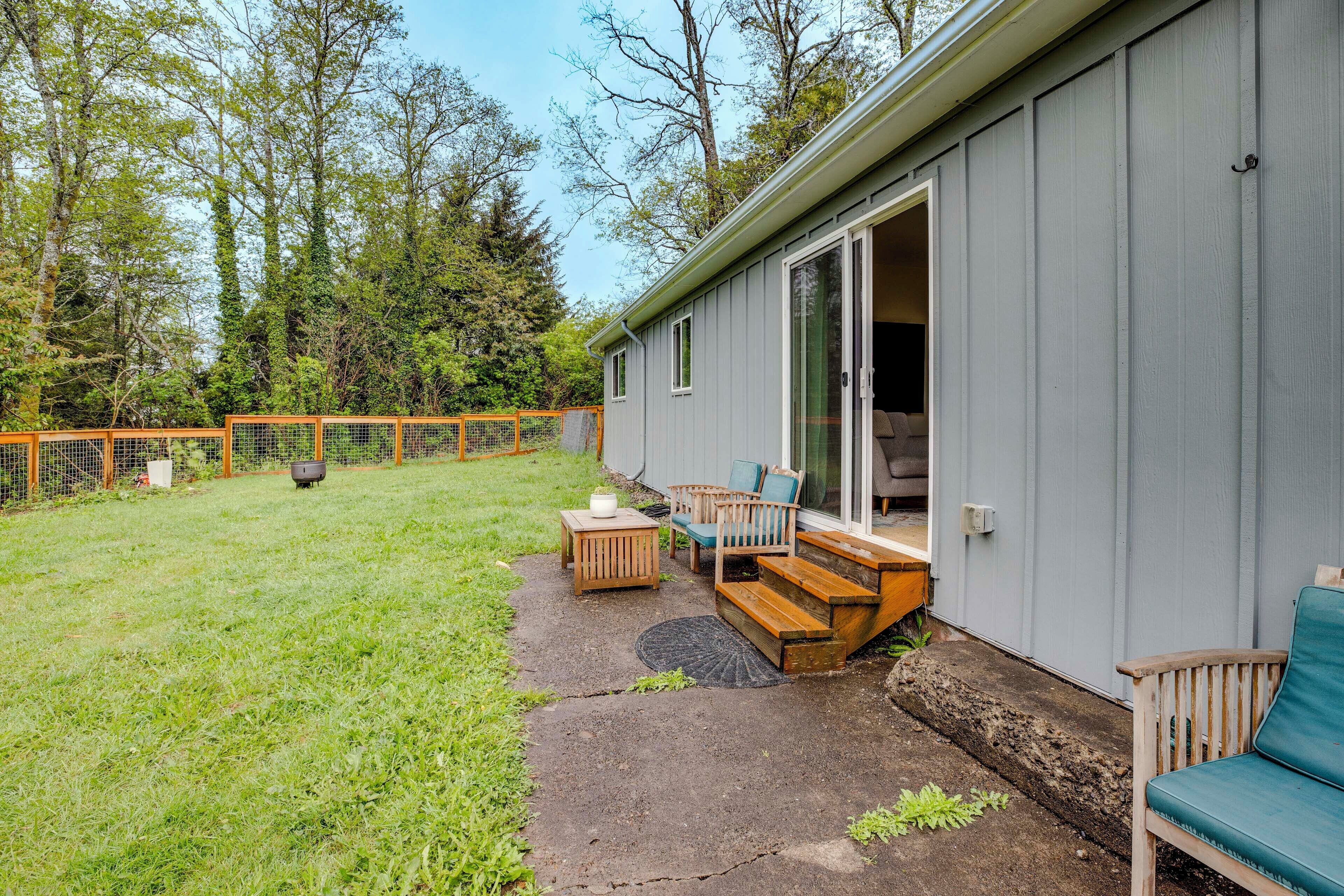 Un patio techado con mobiliario exterior, una terraza de madera y un patio trasero cercado.