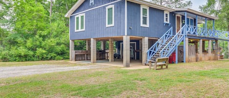 Une maison à deux étages avec un porche et un escalier bleu.