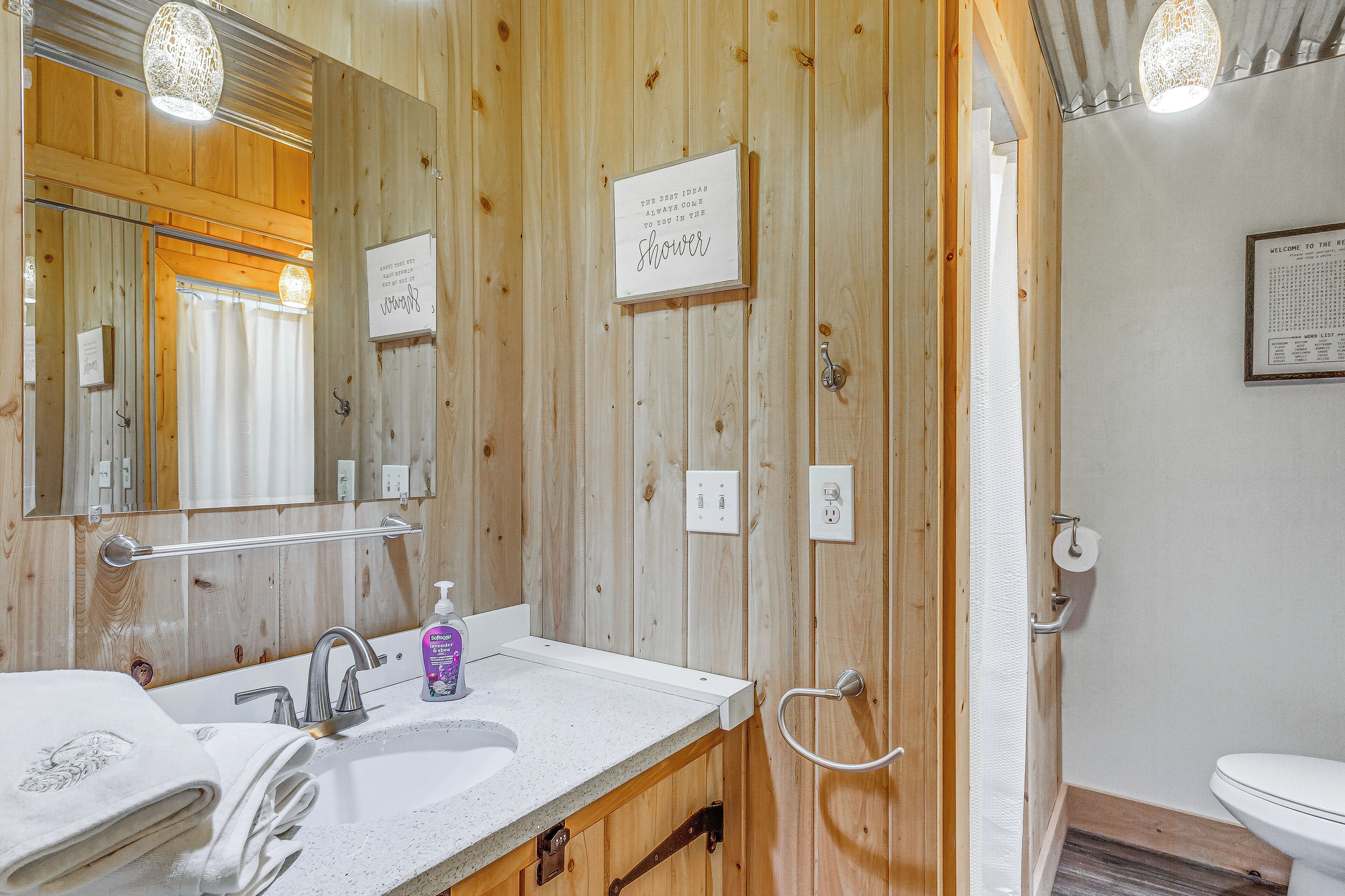 Une salle de bain en bois avec un lavabo, un miroir et une douche.