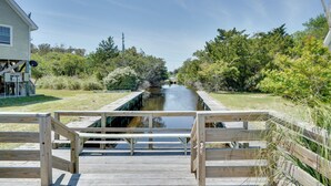 A wooden boardwalk leading to a canal with a house on the left. - Buxton Vacation Rental w/ Shared Canal Access! (Buxton)