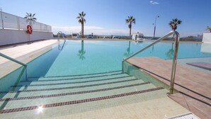 A clear swimming pool with tiled steps leading into it, surrounded by palm trees and a white fence. - Dunas Beach with sea views in Torrox Costa (Torrox Costa)