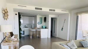 A modern living room with a sofa, a dining table, and a kitchen area with a central island. - Dunas Beach with sea views in Torrox Costa (Torrox Costa)