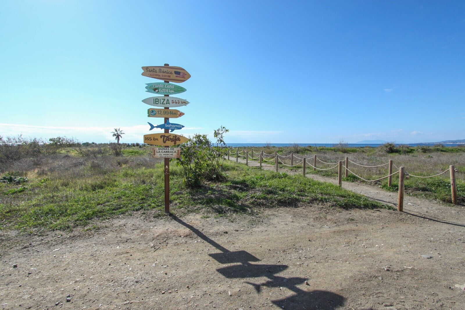 A directional signpost with multiple destinations and distances.