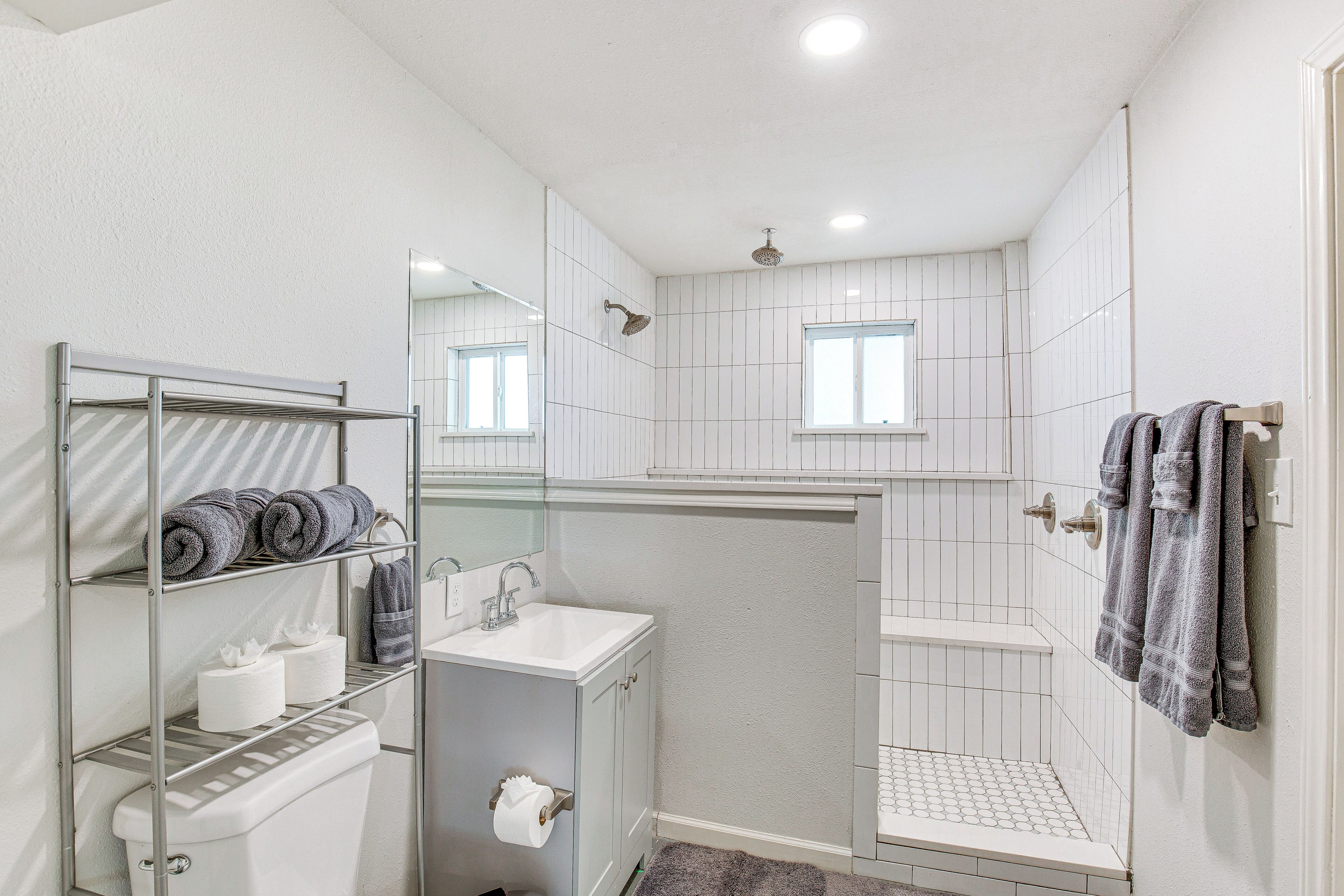 Un baño moderno con ducha, inodoro y lavamanos.