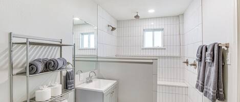 Un baño moderno con ducha, inodoro y lavamanos.