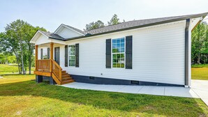 A single-story house with a front porch, a small staircase, and a garage. - Secluded Guntersville Home Near Lake & Marinas! (Guntersville)