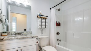 A bathroom with a white toilet, a shower with a glass door, and a sink with a granite countertop. - Secluded Guntersville Home Near Lake & Marinas! (Guntersville)